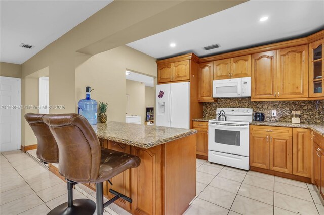 2761 SW 33rd Ct, Miami, FL 33133 - kitchen featuring white appliances, glass insert cabinets, a kitchen breakfast bar, brown cabinets, and light tile patterned floors