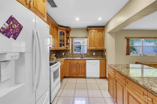 2761 SW 33rd Ct, Miami, FL 33133 - kitchen with white appliances, stone countertops, backsplash, glass insert cabinets, and light tile patterned floors