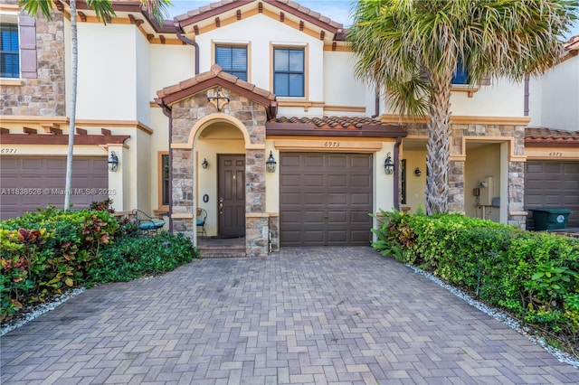 6973 Broadland Way, Coconut Creek, FL 33073 - mediterranean / spanish-style house with a tile roof, stone siding, and stucco siding