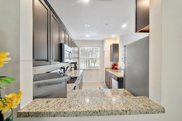 2851 W Prospect Rd Unit 1306, Tamarac, FL 33309 - kitchen featuring stainless steel microwave, light stone counters, light tile patterned floors, stove, and recessed lighting