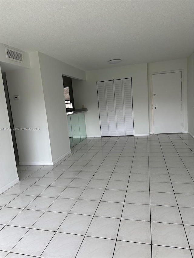 8897 Fontainebleau Blvd Unit 208, Miami, FL 33172 - spare room with a textured ceiling and light tile patterned flooring