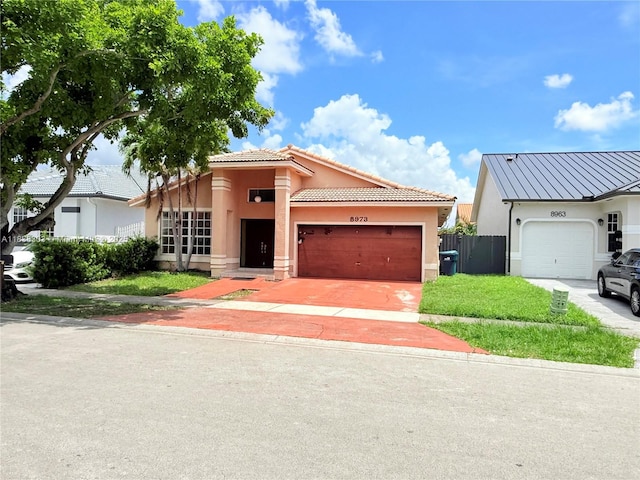 8973 NW 147th Ter, Miami Lakes, FL 33018 - view of front of property with stucco siding, a garage, a tiled roof, and concrete driveway