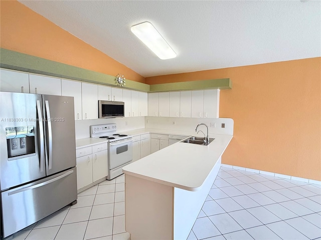 8973 NW 147th Ter, Miami Lakes, FL 33018 - kitchen with stainless steel appliances, vaulted ceiling, a peninsula, light countertops, and white cabinetry