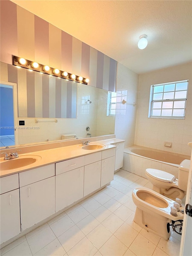 8973 NW 147th Ter, Miami Lakes, FL 33018 - bathroom featuring tile patterned floors, a bidet, tiled bath, and double vanity