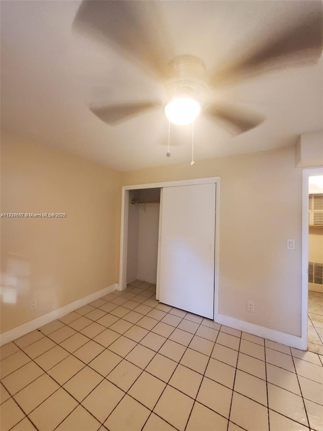 1450 NE 191st St Unit 106, Miami, FL 33179 - unfurnished bedroom with a closet, light tile patterned floors, and ceiling fan