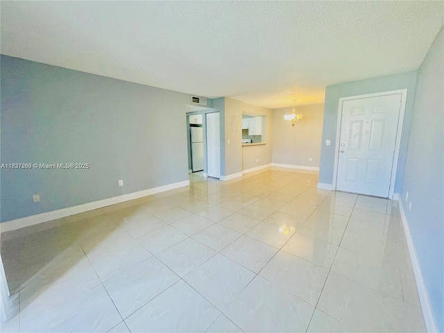1231 SW 46th Ave Unit 507, Pompano Beach, FL 33069 - spare room with a chandelier, light tile patterned floors, and a textured ceiling