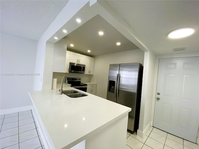5705 W 20th Ave Unit 115, Hialeah, FL 33012 - kitchen with appliances with stainless steel finishes, a peninsula, light countertops, light tile patterned floors, and recessed lighting