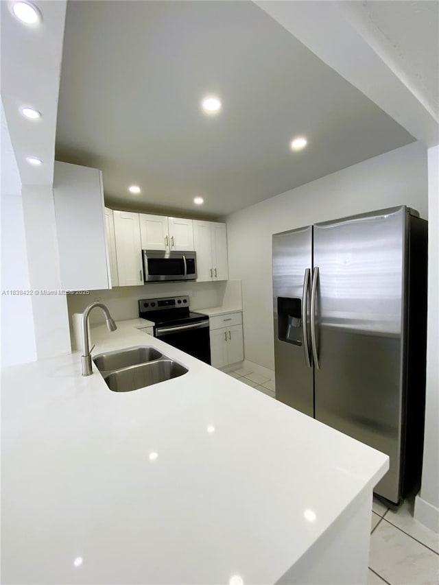 5705 W 20th Ave Unit 115, Hialeah, FL 33012 - kitchen featuring stainless steel appliances, light countertops, white cabinets, recessed lighting, and a peninsula