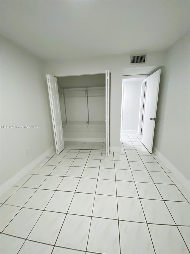 5705 W 20th Ave Unit 115, Hialeah, FL 33012 - unfurnished bedroom featuring a closet and light tile patterned flooring