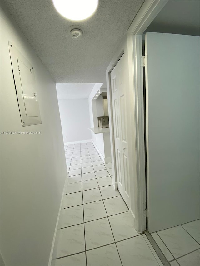 5705 W 20th Ave Unit 115, Hialeah, FL 33012 - hallway featuring a textured ceiling, electric panel, and light tile patterned floors