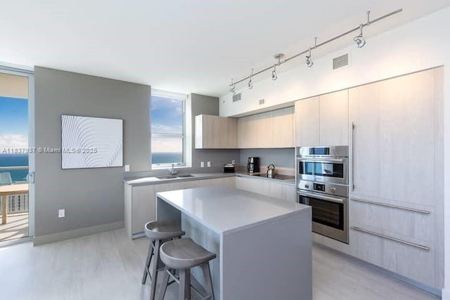 4010 S Ocean Dr Unit T3501, Hollywood, FL 33019 - kitchen with double oven, a center island, light countertops, track lighting, and a breakfast bar