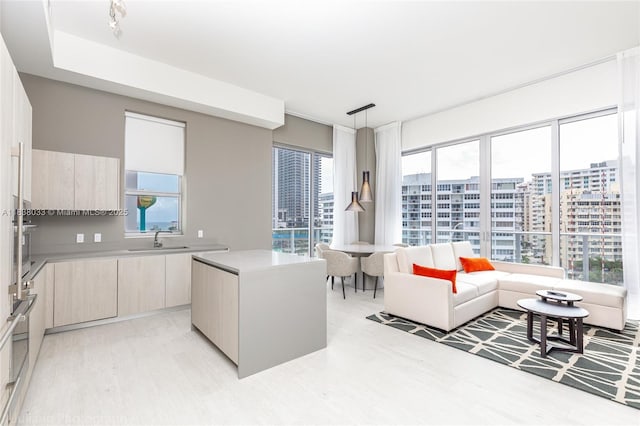4010 S Ocean Dr Unit R409, Hollywood, FL 33019 - kitchen with modern cabinets, light wood-type flooring, a kitchen island, light countertops, and pendant lighting