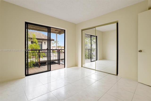 5808 W 26th Ave Unit 211, Hialeah, FL 33016 - unfurnished room with healthy amount of natural light, light tile patterned floors, and a textured ceiling