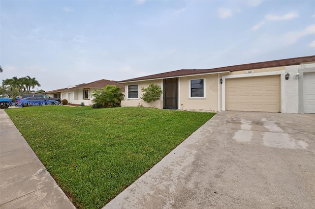 1600 Granfern Ave, West Palm Beach, FL 33415 - single story home with stucco siding, a front yard, concrete driveway, and a garage
