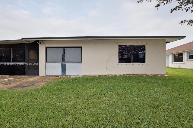 1600 Granfern Ave, West Palm Beach, FL 33415 - view of property exterior with a lawn, stucco siding, and a patio