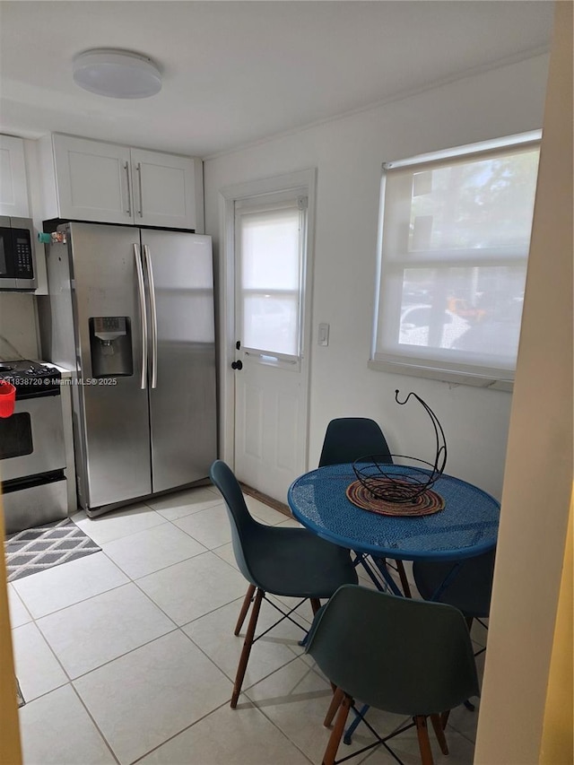 620 NE 12th Ave Unit 101, Hallandale Beach, FL 33009 - kitchen with appliances with stainless steel finishes, light tile patterned floors, and white cabinetry