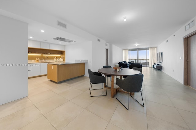1135 103rd St Unit 702, Bay Harbor Islands, FL 33154 - dining space featuring light tile patterned flooring and floor to ceiling windows