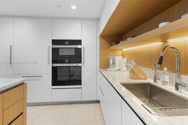 1135 103rd St Unit 702, Bay Harbor Islands, FL 33154 - kitchen with open shelves, light stone countertops, white cabinetry, and light tile patterned flooring