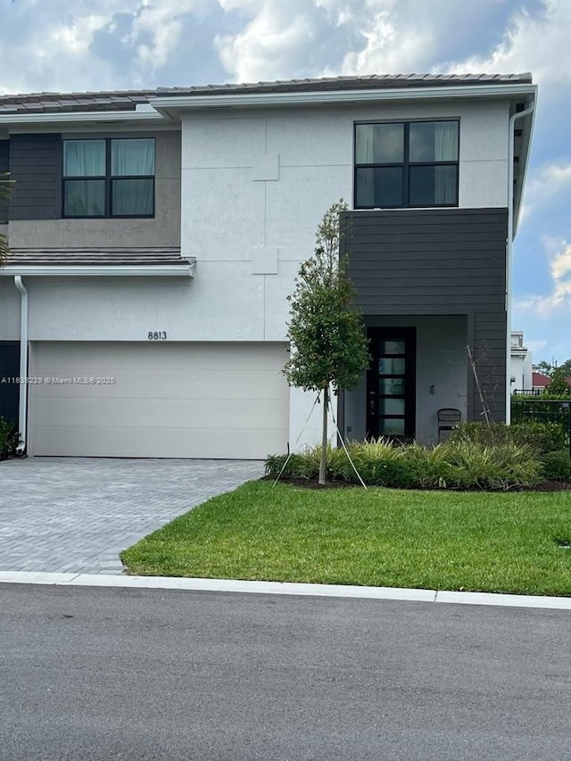 8813 Antarus Dr Unit 8813, Lake Worth, FL 33467 - view of front of house with an attached garage, stucco siding, a front yard, and driveway