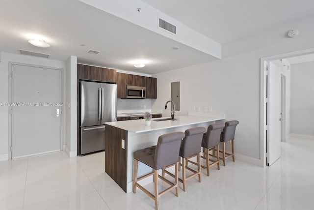 488 NE 18th St Unit 509, Miami, FL 33132 - kitchen with a breakfast bar, appliances with stainless steel finishes, a peninsula, light countertops, and modern cabinets
