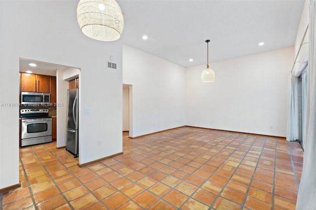 2794 SW 22nd Ave, Miami, FL 33133 - kitchen featuring stainless steel appliances, brown cabinetry, recessed lighting, decorative backsplash, and hanging light fixtures