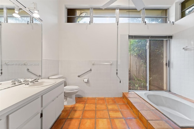 2794 SW 22nd Ave, Miami, FL 33133 - full bathroom with tile walls, a relaxing tiled tub, tile patterned floors, vanity, and healthy amount of natural light