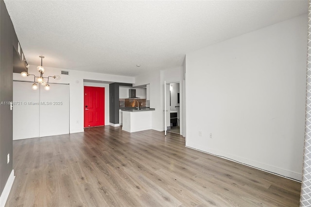5077 NW 7th St Unit Ph15, Miami, FL 33126 - unfurnished living room featuring a chandelier, wood finished floors, and a textured ceiling