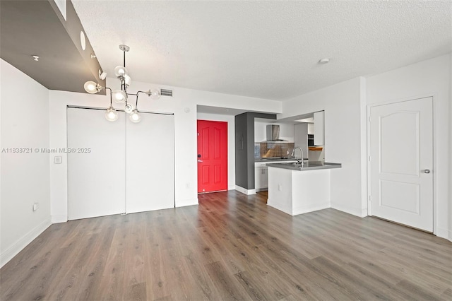 5077 NW 7th St Unit Ph15, Miami, FL 33126 - unfurnished living room featuring a chandelier, dark wood-style floors, and a textured ceiling