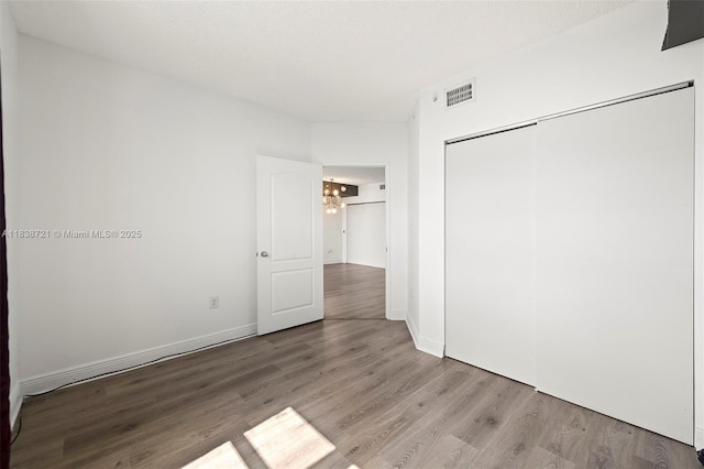 5077 NW 7th St Unit Ph15, Miami, FL 33126 - unfurnished bedroom with wood finished floors, a chandelier, and a closet