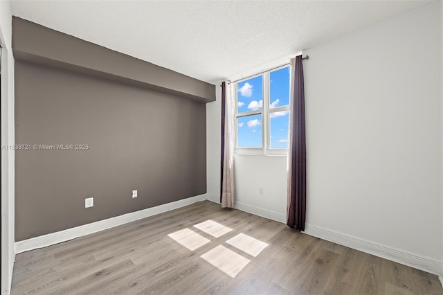 5077 NW 7th St Unit Ph15, Miami, FL 33126 - unfurnished room featuring wood finished floors and a textured ceiling