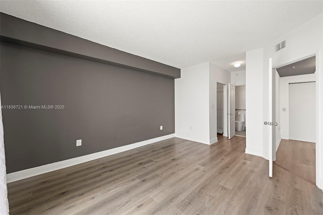 5077 NW 7th St Unit Ph15, Miami, FL 33126 - unfurnished bedroom with wood finished floors, a textured ceiling, and ensuite bathroom