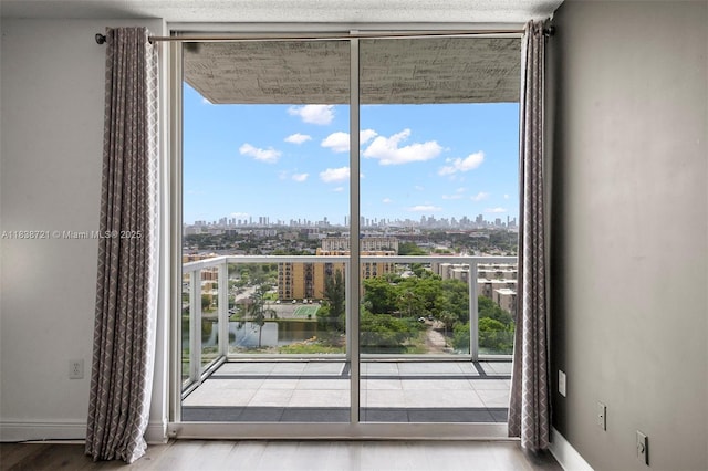 5077 NW 7th St Unit Ph15, Miami, FL 33126 - doorway to outside with plenty of natural light, a skyline view, a wall of windows, and wood finished floors