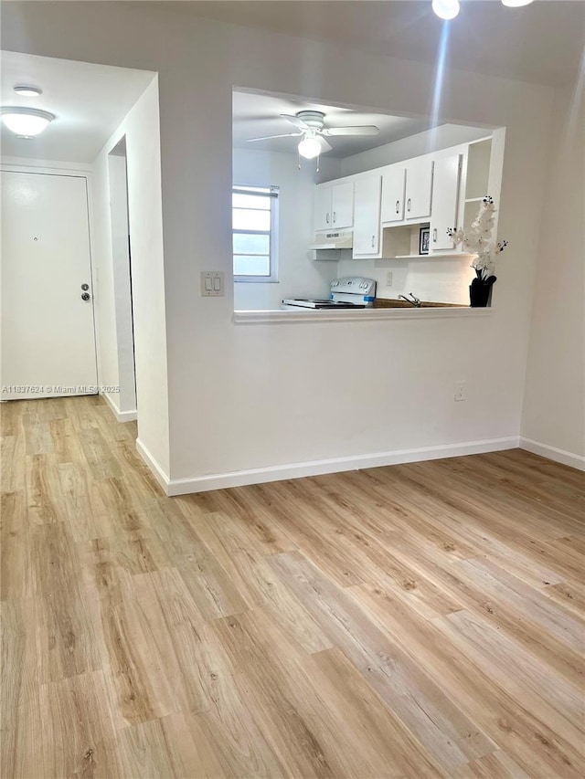 855 Euclid Ave Unit 104, Miami Beach, FL 33139 - kitchen featuring white electric range oven, under cabinet range hood, light wood-style floors, a ceiling fan, and white cabinets