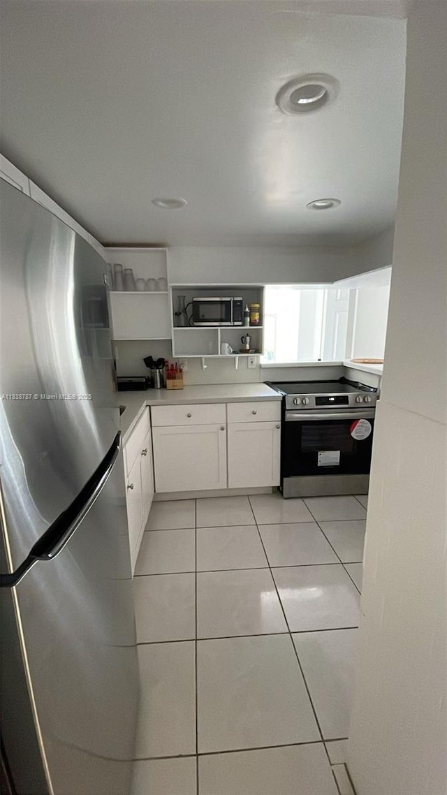 200 172nd St Unit 420, Sunny Isles Beach, FL 33160 - kitchen featuring stainless steel appliances, open shelves, white cabinetry, light tile patterned floors, and light countertops