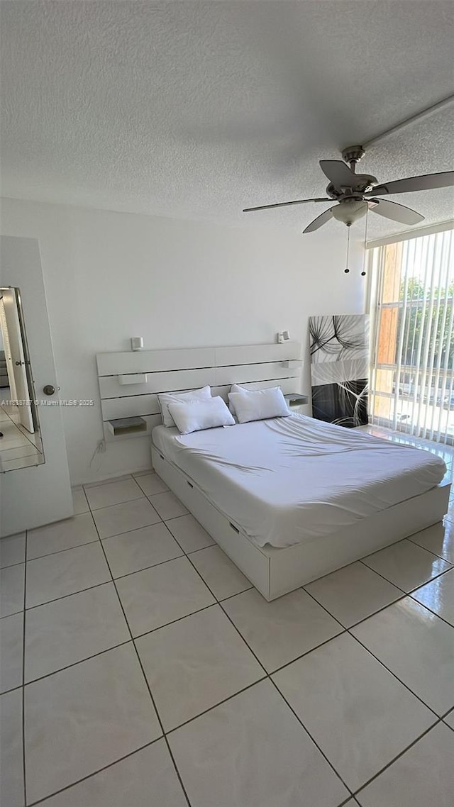 200 172nd St Unit 420, Sunny Isles Beach, FL 33160 - bedroom with tile patterned flooring, a textured ceiling, and a ceiling fan