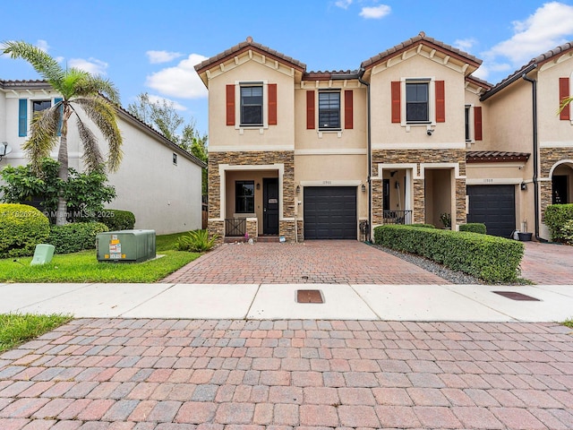 11901 SW 150th Pl, Miami, FL 33196 - mediterranean / spanish house featuring stone siding, stucco siding, decorative driveway, a tiled roof, and a garage