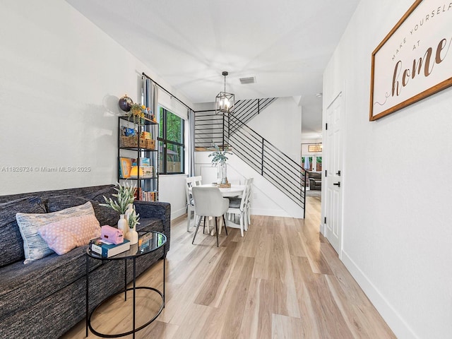 11901 SW 150th Pl, Miami, FL 33196 - dining space featuring a chandelier, light wood-type flooring, and stairs