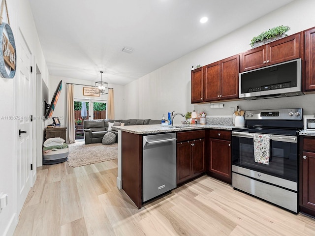 11901 SW 150th Pl, Miami, FL 33196 - kitchen with appliances with stainless steel finishes, light wood-style floors, a peninsula, a chandelier, and recessed lighting