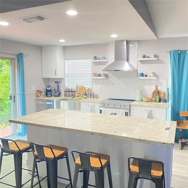 20317 SW 86th Ct, Cutler Bay, FL 33189 - kitchen featuring open shelves, wall chimney range hood, appliances with stainless steel finishes, a kitchen breakfast bar, and recessed lighting