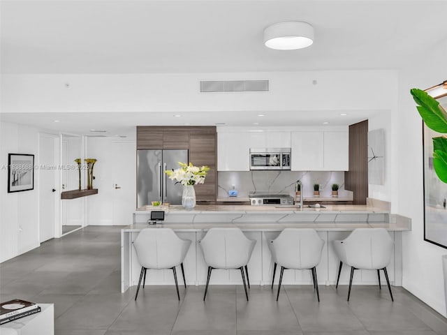 9940 W Bay Harbor Dr Unit 3G-S, Bay Harbor Islands, FL 33154 - kitchen featuring modern cabinets, stainless steel appliances, a kitchen breakfast bar, backsplash, and recessed lighting