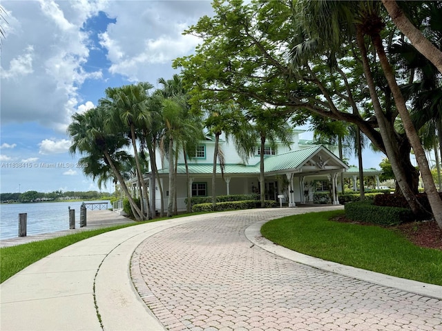 1111 NW 173rd Ave, Pembroke Pines, FL 33029 - view of front of house with curved driveway, a metal roof, and a water view