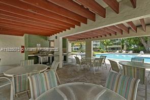 6075 N Sabal Palm Blvd Unit 310, Tamarac, FL 33319 - view of patio featuring outdoor dining space and a community pool