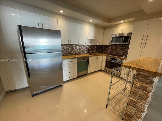 19390 Collins Ave Unit 902, Sunny Isles Beach, FL 33160 - kitchen featuring stainless steel appliances, decorative backsplash, recessed lighting, white cabinets, and dark countertops