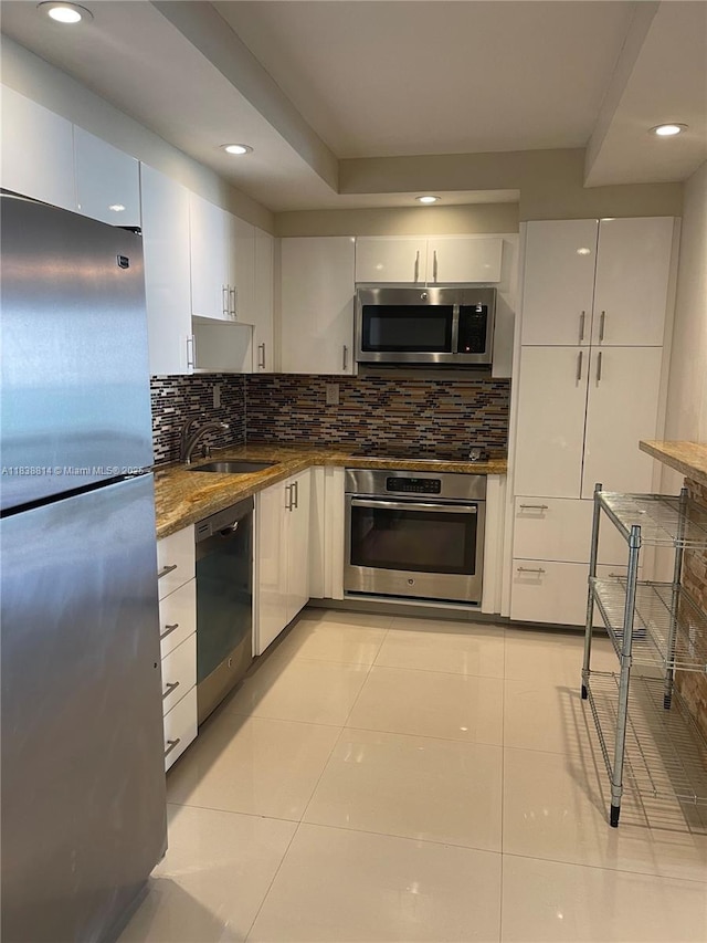 19390 Collins Ave Unit 902, Sunny Isles Beach, FL 33160 - kitchen with appliances with stainless steel finishes, white cabinetry, light tile patterned floors, decorative backsplash, and recessed lighting