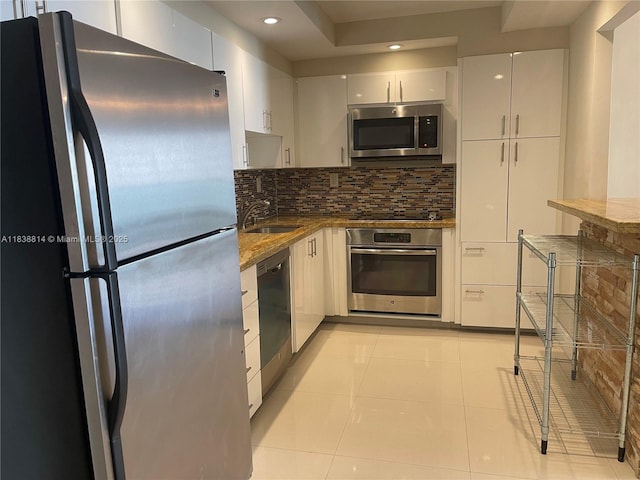 19390 Collins Ave Unit 902, Sunny Isles Beach, FL 33160 - kitchen with appliances with stainless steel finishes, decorative backsplash, recessed lighting, white cabinets, and dark stone countertops