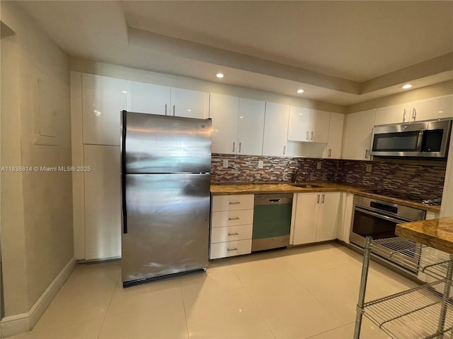 19390 Collins Ave Unit 902, Sunny Isles Beach, FL 33160 - kitchen with appliances with stainless steel finishes, tasteful backsplash, dark countertops, white cabinetry, and recessed lighting