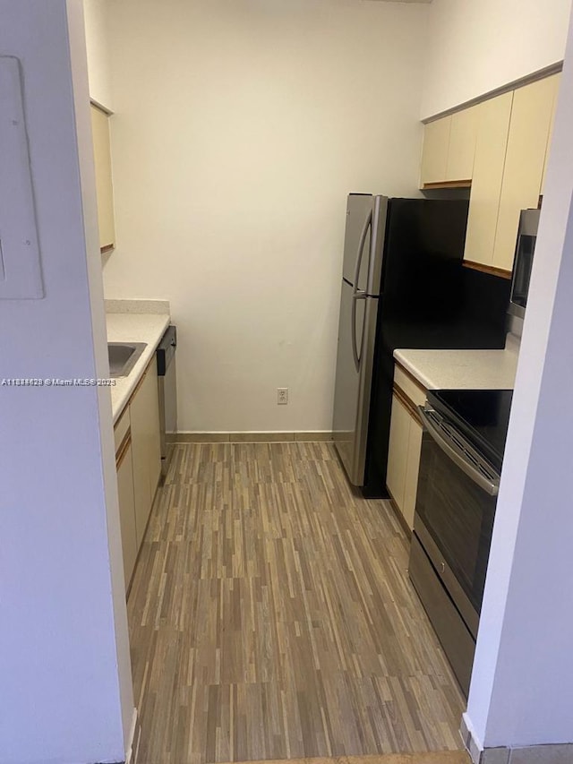 660 Cypress Club Way Unit F11, Deerfield Beach, FL 33064 - kitchen featuring appliances with stainless steel finishes, light countertops, and light wood-style flooring