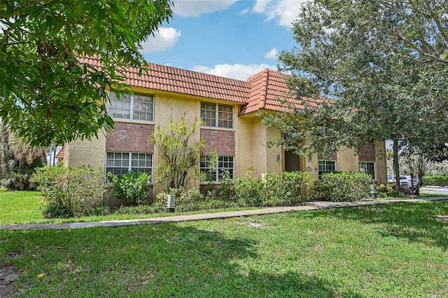 8103 NW 27th St Unit 1, Coral Springs, FL 33065 - view of front of house with a front lawn, a tile roof, stucco siding, and brick siding
