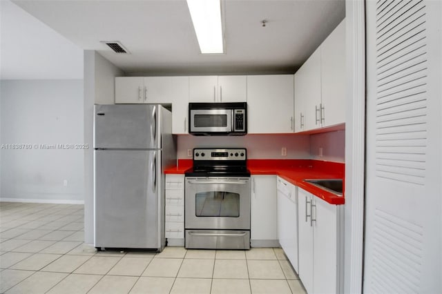 3410 Coral Way Unit 904, Miami, FL 33145 - kitchen featuring appliances with stainless steel finishes, white cabinets, dark countertops, and light tile patterned flooring