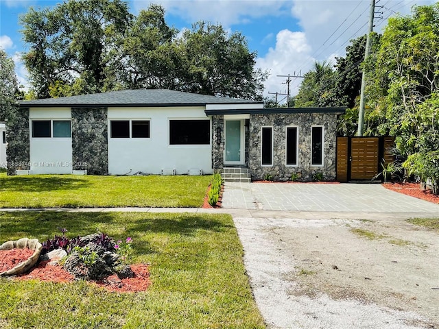1930 NE 178th St, North Miami Beach, FL 33162 - view of front of property with stone siding, driveway, and stucco siding